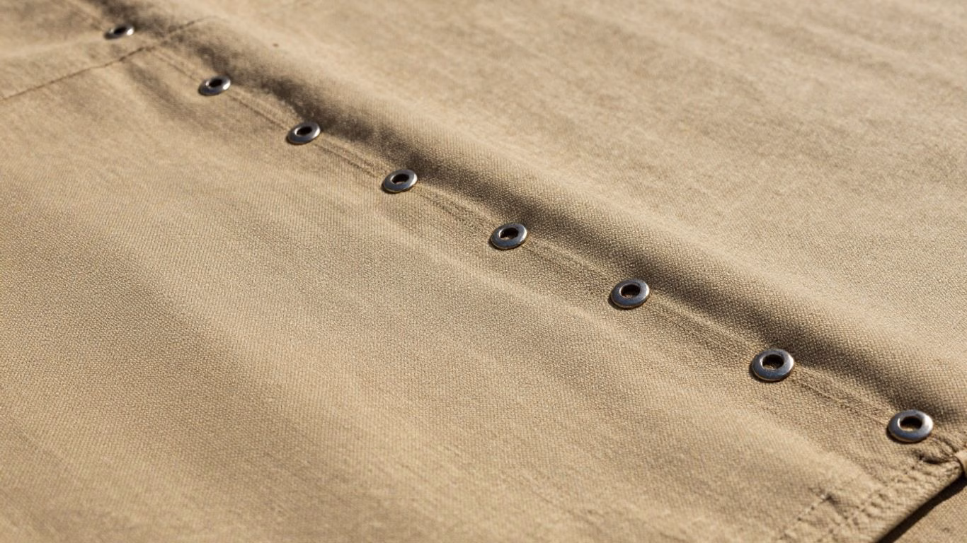 Durable canvas tarpaulin with visible weave and grommets.